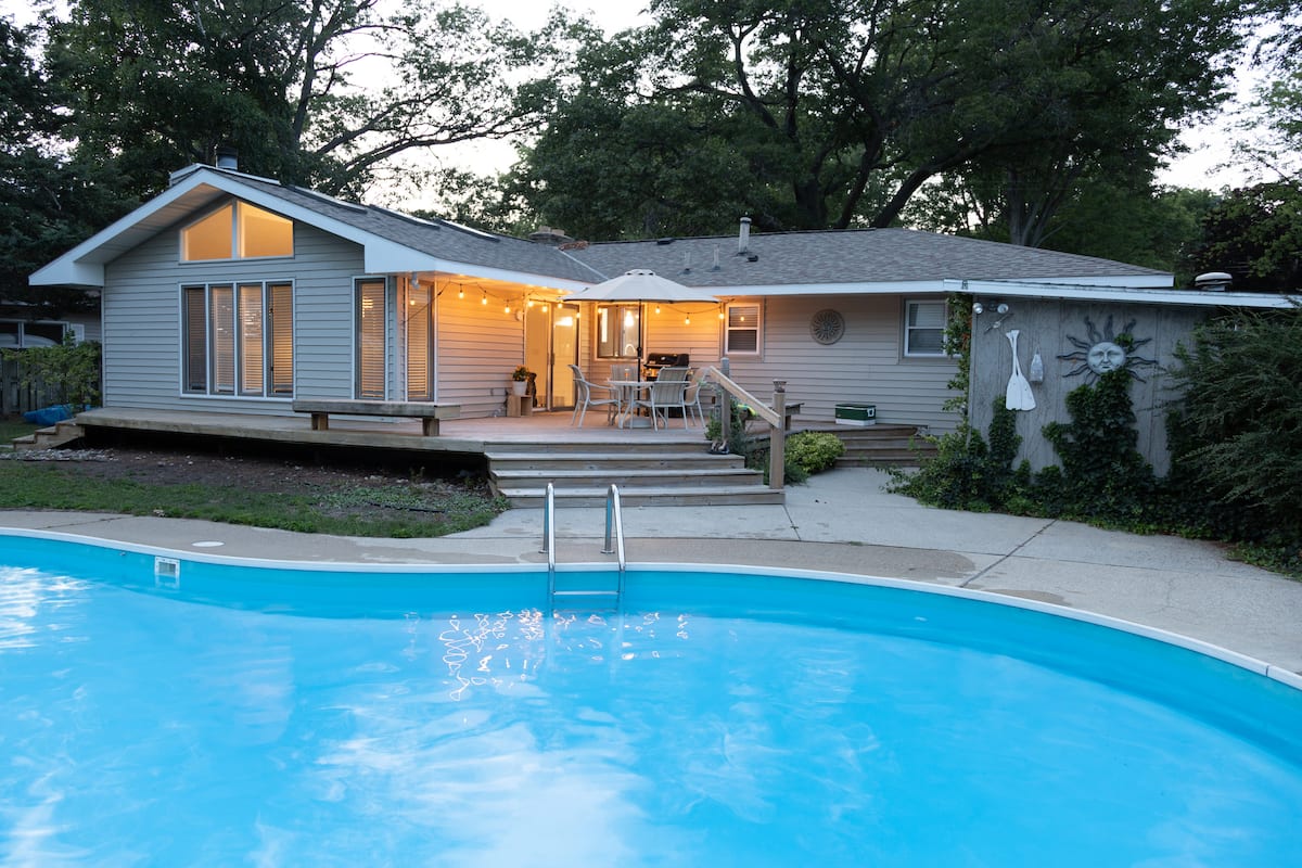 Pool and house exterior at dusk with string lights